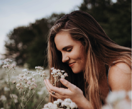 Woman-smelling-flowers-in-field
